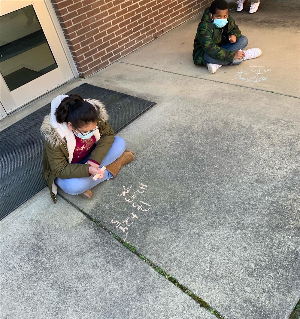 Students doing math on the sidewalk